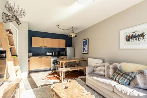 un salon avec un canapé et une cuisine dans l'établissement Résidence Lodges 1970 - Résidence LES LODGES 1970 N°B503 MAE-1531, à La Plagne Tarentaise