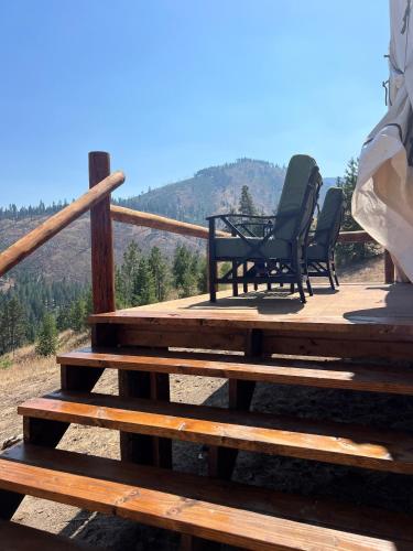 two chairs and a table on a wooden deck at Tent 1 Oxen-Le-Fields Montana in Sula