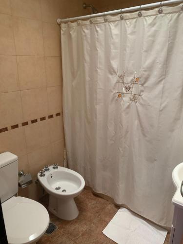a bathroom with a toilet and a shower curtain at Fenix 2 in Colón