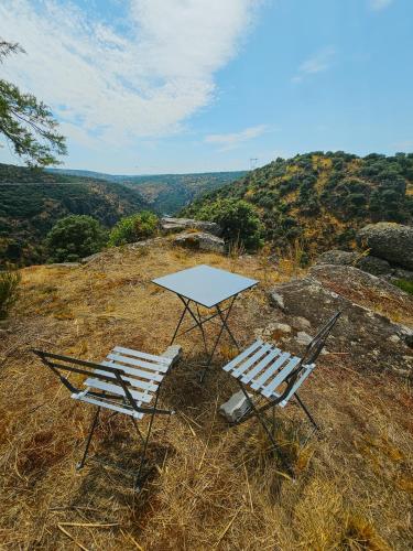 two chairs and a table on top of a hill at Junção - Apartamentos Completos in Miranda do Douro