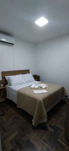 Un dormitorio con una cama con dos toallas encima. en Sunset Living 317, en Cachoeira do Sul