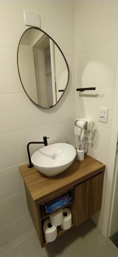 Un baño con un lavabo blanco y un espejo. en Sunset Living 317, en Cachoeira do Sul