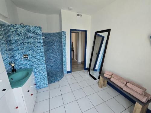 une salle de bain avec un lavabo vert et un miroir dans l'établissement Maison de ville, spacieuse et cosy, à Montélimar