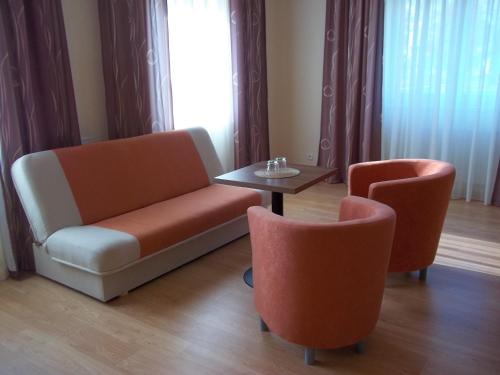 a living room with two chairs and a table at Blatenský dvůr in Pardubice