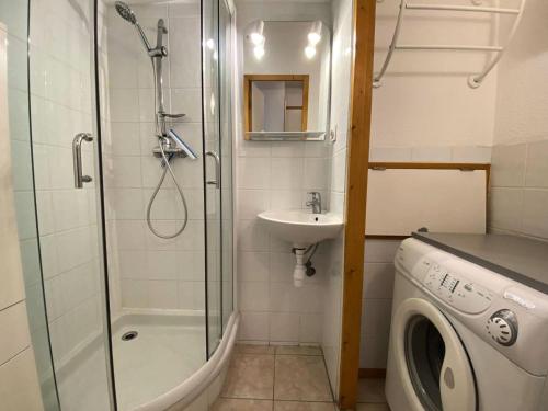 une salle de bain avec douche et lavabo et une machine à laver dans l'établissement Résidence Soleil - Appartement T2 skis aux pieds avec vue sur les montagnes et place de parking privée couverte MAE-5401, à Vénosc