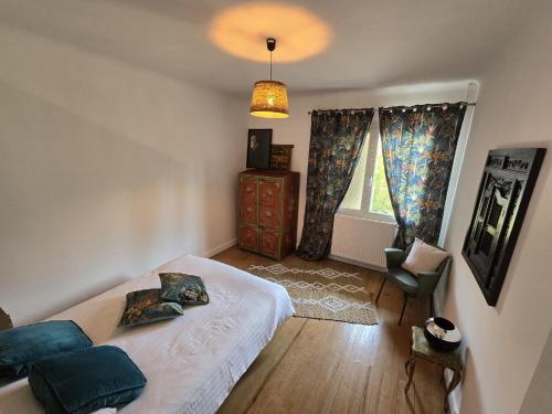 une chambre avec un lit, une chaise et une fenêtre dans l'établissement Maison de ville, spacieuse et cosy, à Montélimar