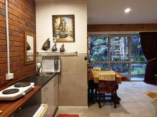 una cucina con lavandino, tavolo e finestra di Your stay starts with dinner in our home a Whanganui