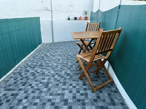 ein Holztisch und ein Stuhl auf einer Terrasse in der Unterkunft Casa ao centro - Apartamento Angrego in Angra do Heroísmo