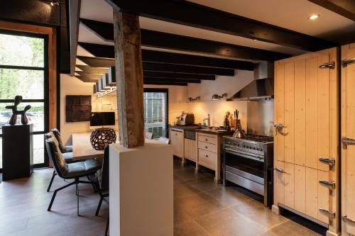 a kitchen with wooden cabinets and a table and a stove at Luxe Hofstede met paardenstalling in Lunteren