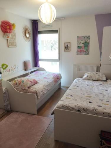 une chambre avec deux lits et une fenêtre dans l'établissement Proche Cité du vin - idéal famille - Parking privé, à Bordeaux