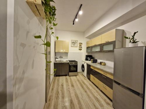 a kitchen with a stainless steel refrigerator and wooden floors at Wrocławska 6 in Świdnica