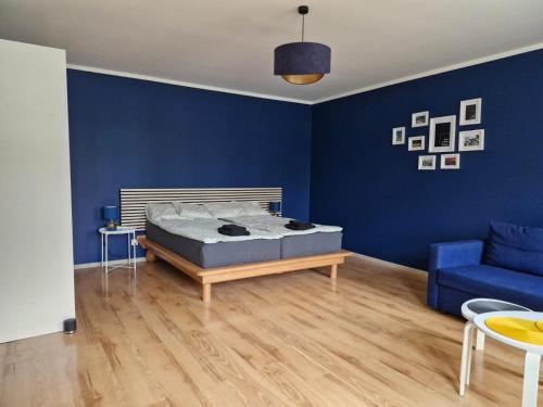 a blue bedroom with a bed and a blue couch at Wrocławska 6 in Świdnica