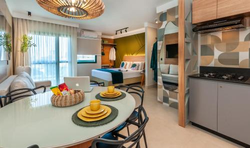 a kitchen and a living room with a table and chairs at Flat Espetacular PRAIA Long Stay in Vitória