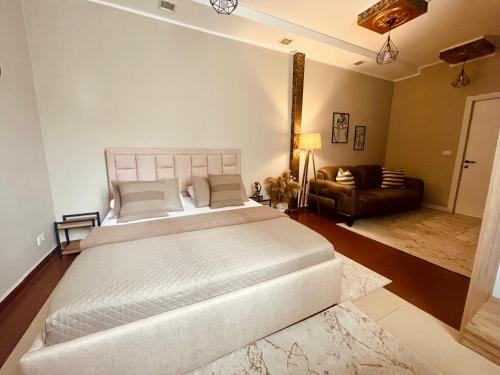 una camera da letto con un grande letto bianco e un divano di Barbaras room a Shkodër