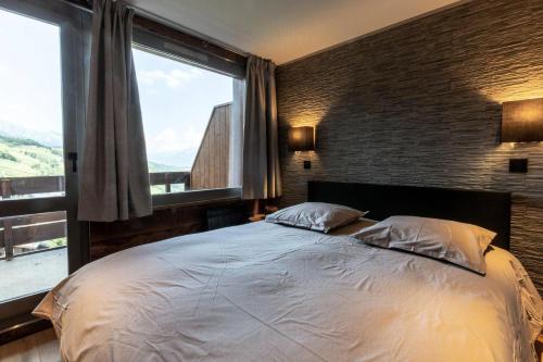 une chambre avec un grand lit avec une grande fenêtre dans l'établissement Résidence Portail G - PORTAIL 32-33 MAE-1401, à Valmorel