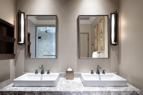 two sinks in a bathroom with two mirrors at The Cromwell, A Caesars Destination in Las Vegas