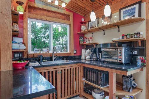 a kitchen with a counter and a sink and a window at Pahoa Paradise Palms in Pahoa