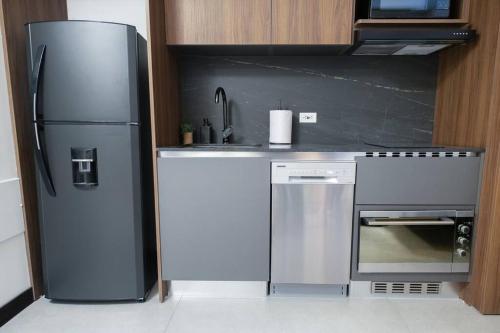 a kitchen with a refrigerator and a stove at Nuevo y moderno apto en Virrey in Bogotá