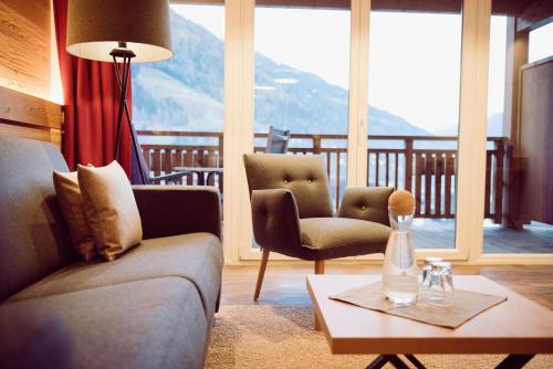a living room with a couch and two chairs and a table at SPA & Naturhotel Outside in Matrei in Osttirol