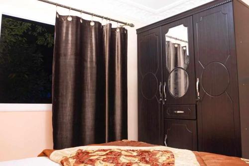 a bedroom with a bed and a black curtain at Hotel Ain Leuh in Aïn Leuh