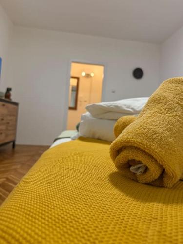 a yellow blanket on a bed in a room at Príjemný apartmán v centre mesta in Martin
