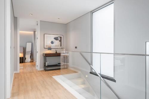 um corredor com paredes brancas e uma escada de vidro em Bayview Villa Retreat no Funchal