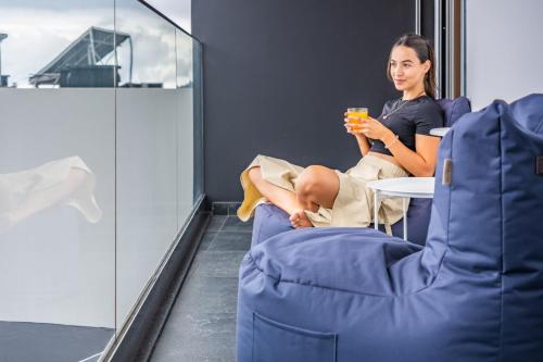 a woman sitting in a chair drinking a drink at Bayview Villa Retreat in Funchal