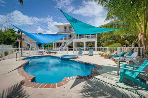 a swimming pool with a hammock in front of a house at Ocean View with Pool, 4 bedroom Vila Near Key West in Cudjoe Key