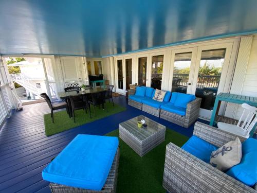 a screened in porch with blue furniture and a table at Ocean View with Pool, 4 bedroom Vila Near Key West in Cudjoe Key