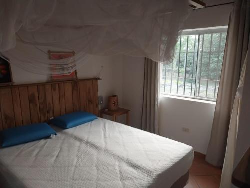 une chambre avec un grand lit blanc avec une fenêtre dans l'établissement Casita de Piedra, à Atyrá