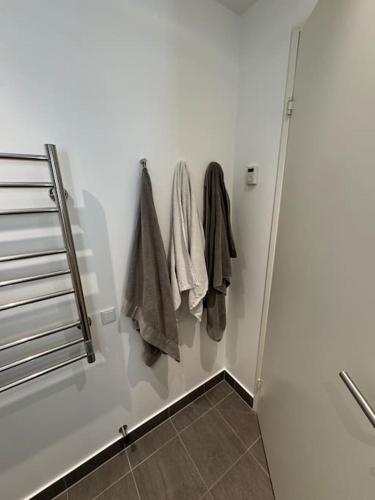 a white bathroom with towels hanging on a wall at Flot Moderne Lejlighed byder Velkommen in Vesterled