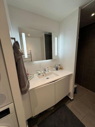a bathroom with a sink and a mirror at Flot Moderne Lejlighed byder Velkommen in Vesterled
