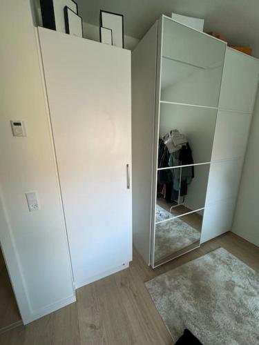 a white cabinet with a mirror in a room at Flot Moderne Lejlighed byder Velkommen in Vesterled