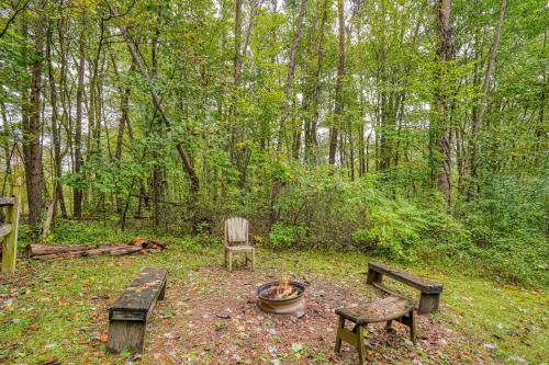 a fire pit and a chair in a forest at Cherokee in Logan