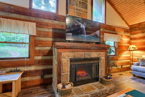 a living room with a fireplace with a tv on top at Cherokee in Logan
