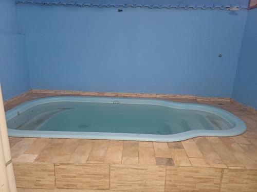 a blue tub in a room with a wooden floor at Casa Da Arlete perto da basilca in Aparecida