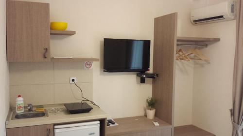 a kitchen with a sink and a tv on the wall at Apartments Fortunella in Budva