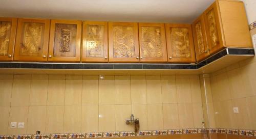 a kitchen with wooden cabinets on the wall at Hotel Ain Leuh in Aïn Leuh