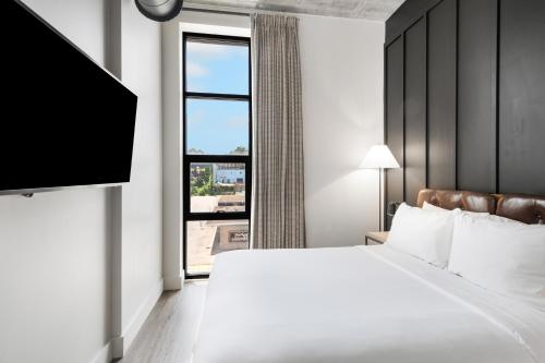 a bedroom with a bed and a large window at Waymore's Guest House & Casual Club in Nashville
