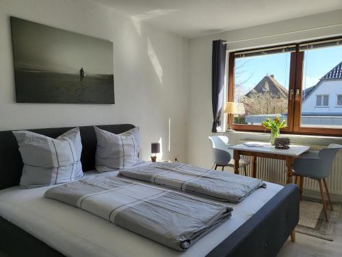 une chambre avec un lit, un bureau et une fenêtre dans l'établissement Fewo Glücksiel, à Sankt Peter-Ording