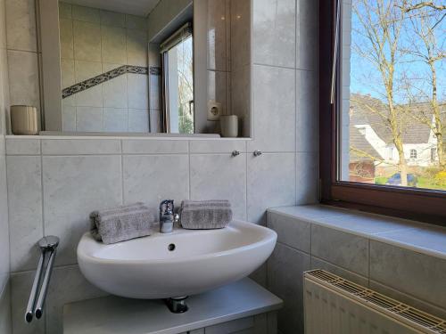 une salle de bains avec un lavabo blanc et un miroir dans l'établissement Fewo Glücksiel, à Sankt Peter-Ording