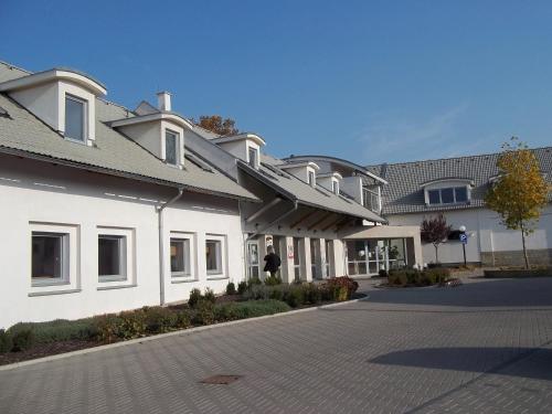 a large white building on a street at Blatenský dvůr in Pardubice