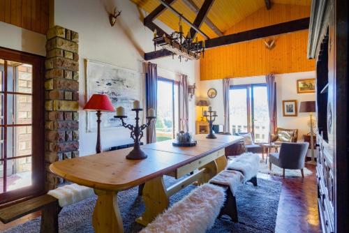 un salon avec une table en bois et un canapé dans l'établissement Grand chalet de charme cosy, sauna & vue de rêve, à Ban-sur-Meurthe-Clefcy