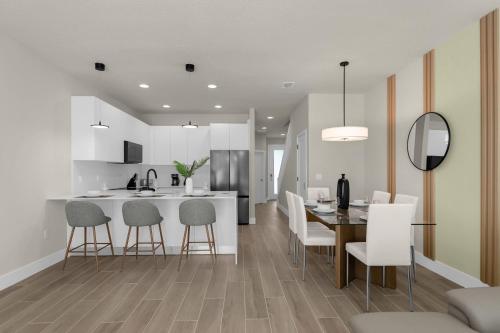a kitchen and dining room with a table and chairs at Upstay - Townhouse with Private Pool and Foosball in Orlando