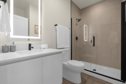a white bathroom with a toilet and a shower at Upstay - Townhouse with Private Pool and Foosball in Orlando
