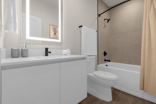 a white bathroom with a sink and a toilet at Upstay - Townhouse with Private Pool and Foosball in Orlando