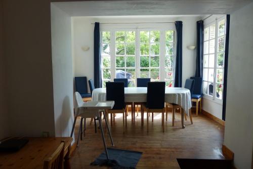 une salle à manger avec une table et des chaises blanches dans l'établissement Maison pour familles et amis, à Dinard
