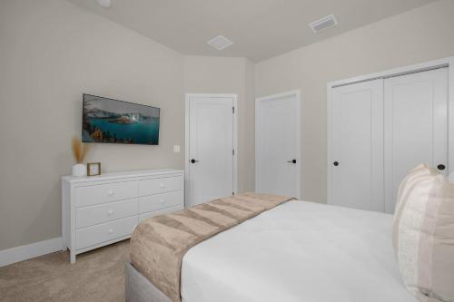 a white bedroom with a bed and a white dresser at Upstay - Townhouse with Private Pool and Foosball in Orlando
