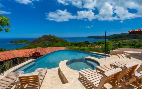a swimming pool with chairs and a view of the ocean at Private Villa, Infinity Pool, 2 Quiet Beaches in Potrero