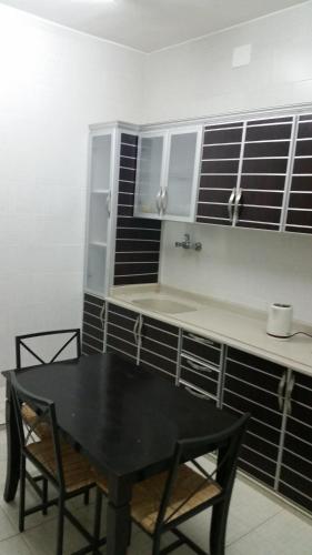 a dining room with a black table and chairs at Bahget Eljouf Furnished Apartment in Sakakah